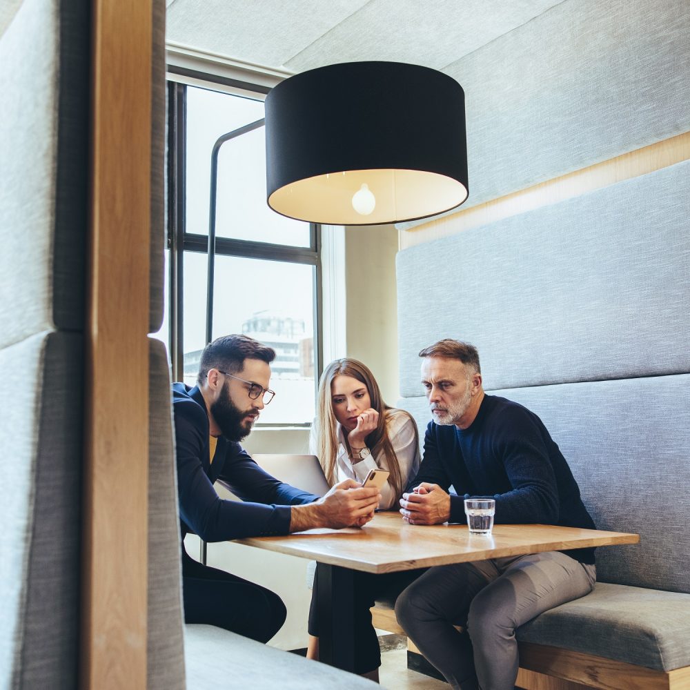 Group,Of,Businesspeople,Working,In,A,Co-working,Space.,Three,Business