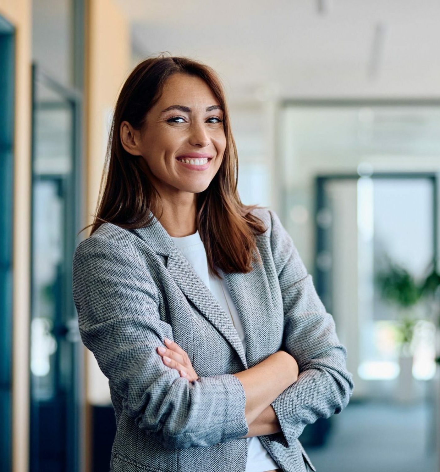 Young,Happy,Businesswoman,With,Arms,Crossed,Standing,Int,He,Office
